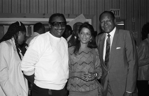 Tom Bradley posing with an unidentified couple at a Communications Bridge Institute event, Los Angeles, 1987