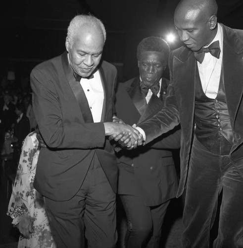 Louis Gossett, Jr. guiding Roy Wilkins to the stage during the NAACP Image Awards, Los Angeles, 1978