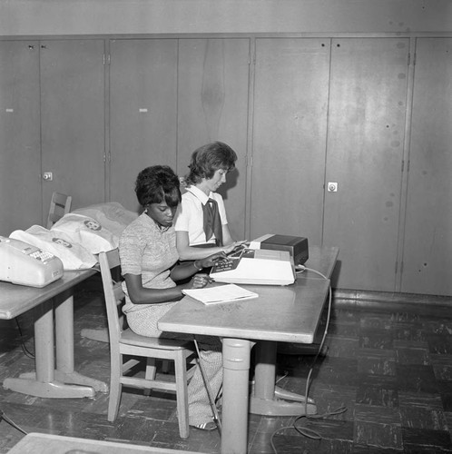 Students working with electric adding machines at Compton College, Compton, 1972