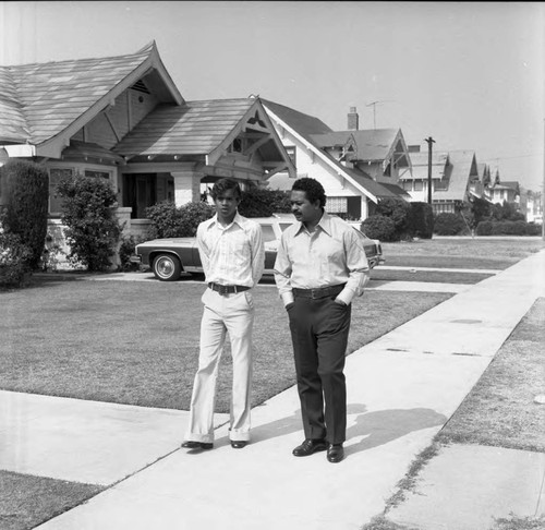 Mervyn Dymally walking in his neighborhood with his son Mark Dymally, Los Angeles, 1973