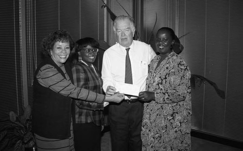 Los Angeles Urban League staff pose holding a check, Los Angeles, 1994