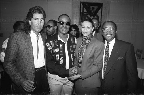 Stevie Wonder posing with others at press conference, Los Angeles, 1989
