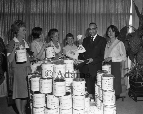 Rev. Thomas Kilgore, Jr. holding donations raised by the "Women For" organization, Los Angeles, 1965