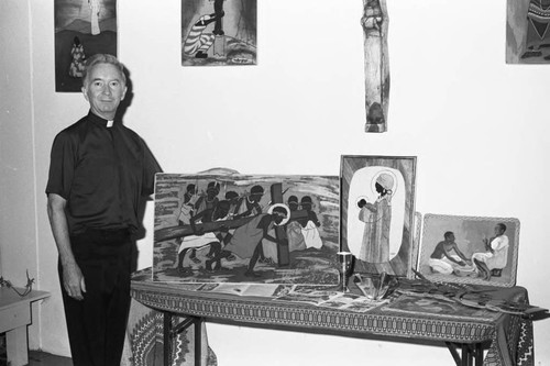 Father Pat posing with artwork from Zambia at Serra High School, Gardena, California, 1983