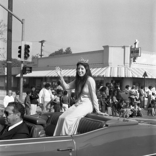 Watts Christmas Parade Queen waving from the back of a convertible, Los Angeles, 1975