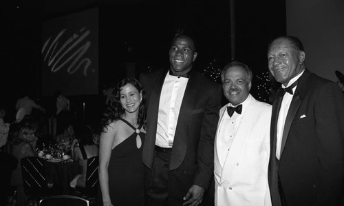 Magic Johnson and Tom Bradley posing with others during "A Midsummer Night's Magic" dinner, Los Angeles, 1995