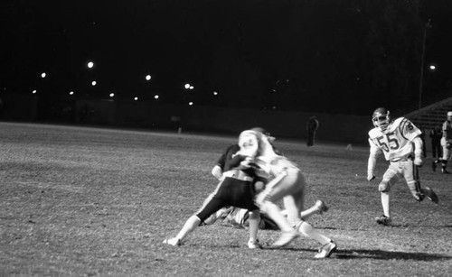 Crenshaw High School football player tackling a Banning player, Long Beach, California, 1982