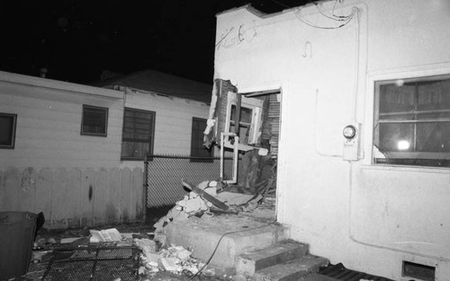 Destroyed entry to a house after a publicized police raid, Los Angeles, 1985