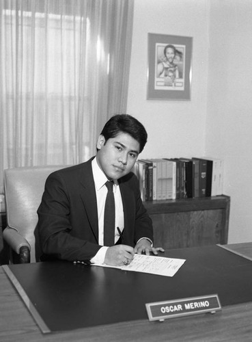 Oscar Merino sitting as his desk at Broadway Federal Savings and Loan, Los Angeles, 1986