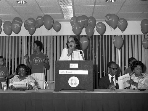 Charlton Pollard High School reunion guest speaking at a lectern, Los Angeles, 1983