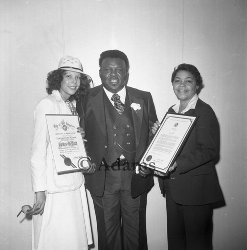 Man and two women holding certificates, Los Angeles, 1977