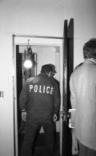 Police walking through a house during a publicized neighborhood raid, Los Angeles, 1985