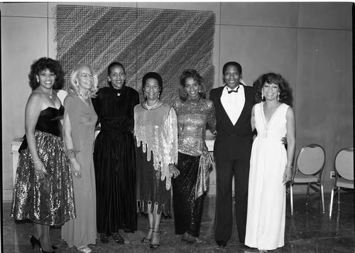 Six women and a man posing for a group portrait during a formal event, Los Angeles, 1989