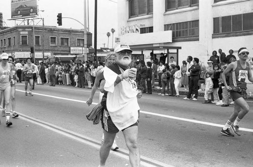 Runners passing spectators on Crenshaw Blvd. during the first LA Marathon, Los Angeles, 1986