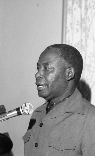 Zambian Ambassador Nalumino Mundia speaking at a lectern, Los Angeles, 1986