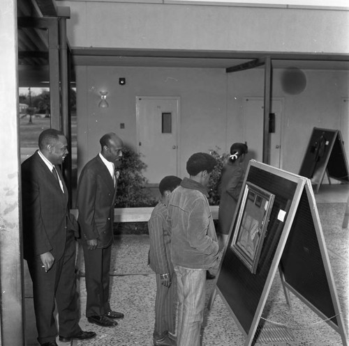 Dr. Abel B. Sykes, Jr. admiring an artwork at Compton College, Compton, 1972