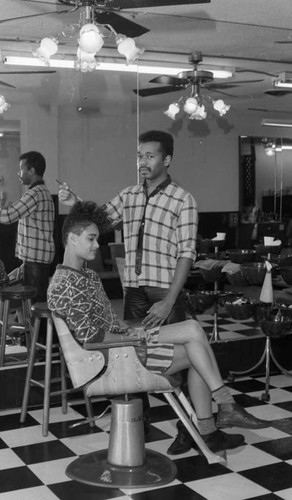 Hairdresser styling his client's hair in a salon, Los Angeles, 1986