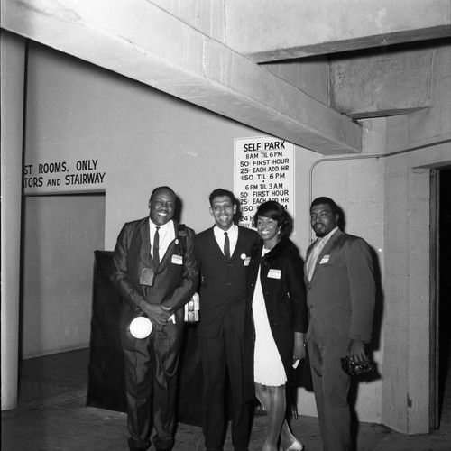 Three men and a woman posing at a Tom Bradley mayoral campaign event, Los Angeles, 1969