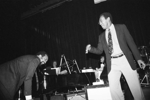 Bill Cosby joking with Quincy Jones at a Neighbors of Watts benefit, Los Angeles, 1982