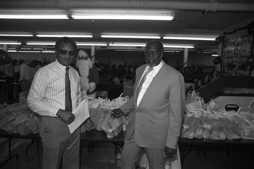 Lee Moses and Holbert Holms posing during a Black Track, Inc. food give-a-way, Los Angeles, 1990