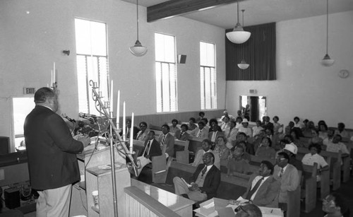 People listening to a speaker discuss gambling, Compton, California, 1982