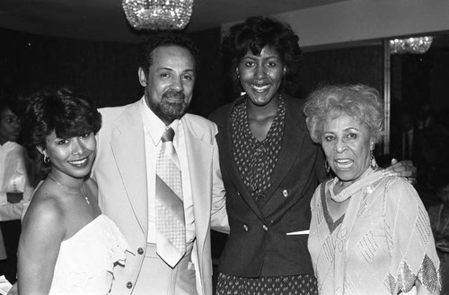 Kenneth Thomas and Jennifer Thomas posing with others at the Ebony Fashion Fair, Los Angeles, 1984