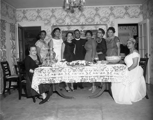 Minister and women at dining table, Los Angeles