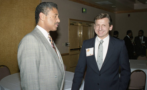 Atkins & Evans holiday party guest talking with Nelson L. Atkins, Los Angeles, 1994