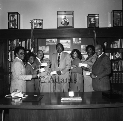 Bradley and others holding checks, Los Angeles, 1982