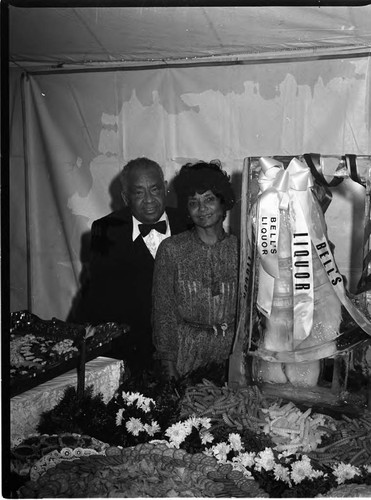 African American couple posing with Bell's Liquor ice sculpture, Los Angeles, 1983