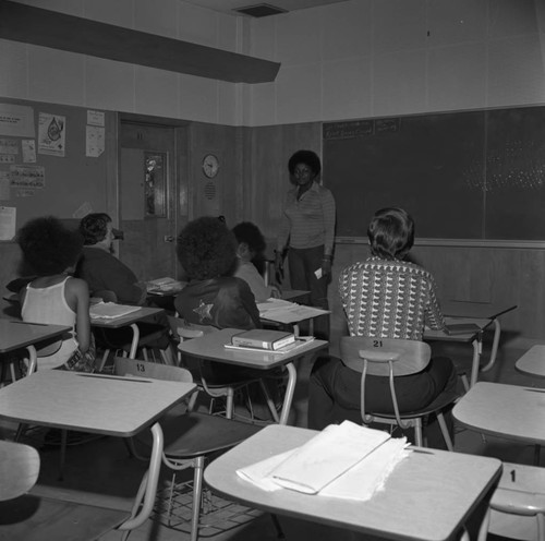 Students listening to an instructor in a classroom at Compton College, Compton, 1972