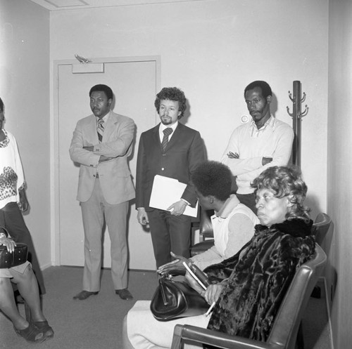 Men and women waiting in an office at Compton College, Los Angeles, ca. 1972