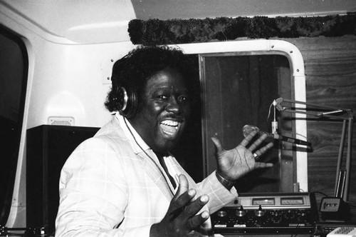 Radio broadcaster performing in a mobile studio, Los Angeles, 1980