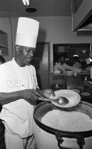 Chef at Murray's Café preparing a plate in the kitchen, Los Angeles, 1982