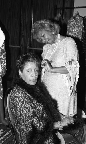 Harriet Hurd receiving a beauty touch-up from Vergee Huddleston for the Fantasy in Dreamland fashion show, Los Angeles, 1986