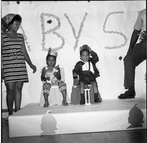 Baby contest winners posing on stage with their crowns and trophies, Los Angeles, 1970