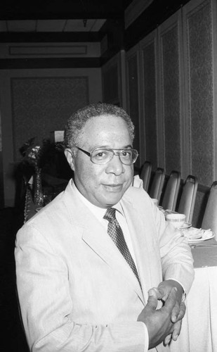 Alex Haley standing at a speakers table in a hotel ballroom, Los Angeles, 1983