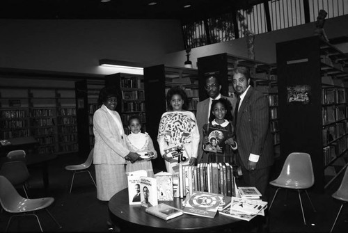 George Hill family posing with their book donation, Los Angeles, 1985