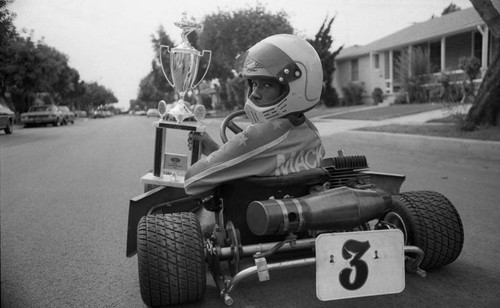 George Mack posing in his go-kart with a trophy, Los Angeles, 1982 ...