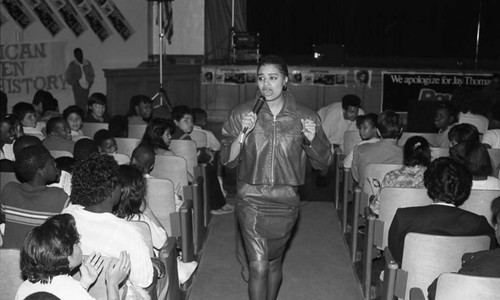 Woman walking through an audience at Bret Harte Middle School, Los Angeles, 1989