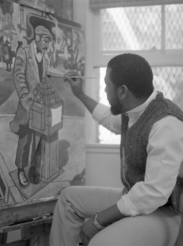 Ernest Johnson applying his paint brush to a canvas, Los Angeles, 1983