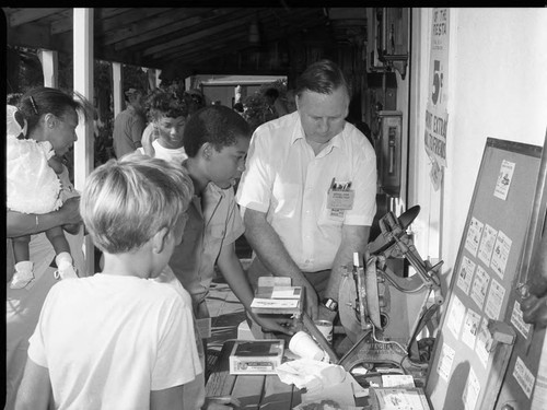 Centinela Adobe Fiesta participants observing antique machinery in action, Los Angeles, 1983