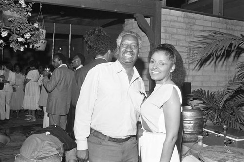 Howard Morehead posing with an unidentified women during an evening event, Los Angeles, 1982