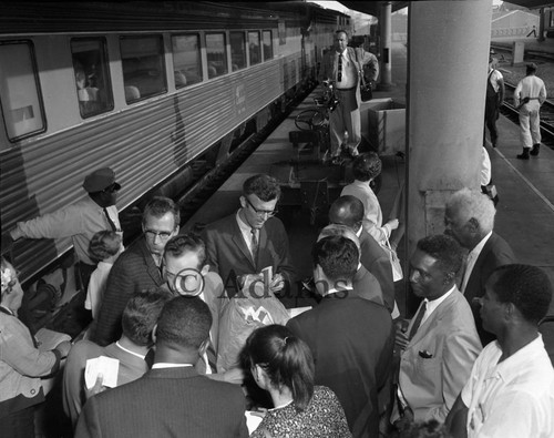 Group talking to a man during the arrival of a displaced Louisiana family, Los Angeles, 1961