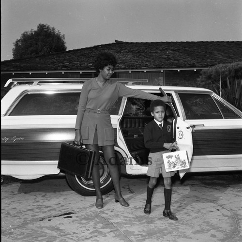 Nancy Wilson helping her son step from a Ford LTD Country Squire station wagon, Los Angeles, 1969