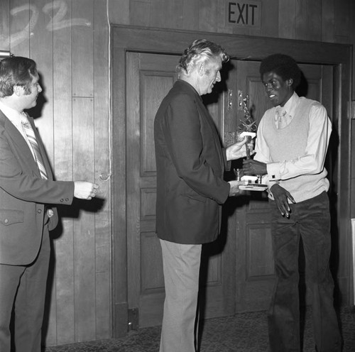 Ernest Hall receiving a trophy from Ken Carpenter at the Compton College basketball awards dinner, Hawthorne, California, 1973