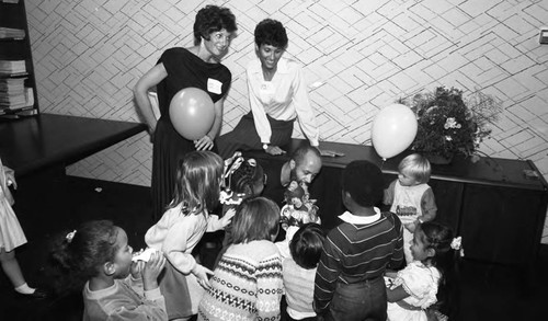 Children gathering around a man with a puppet, Los Angeles, 1985