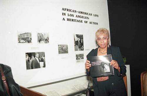 Guy Crowder exhibit guest holding the exhibit catalog, Los Angeles, 1993