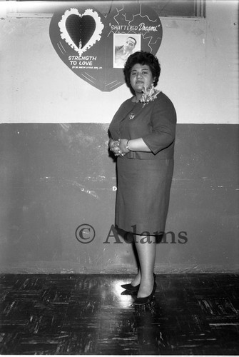 Woman next to poster, Los Angeles, 1963