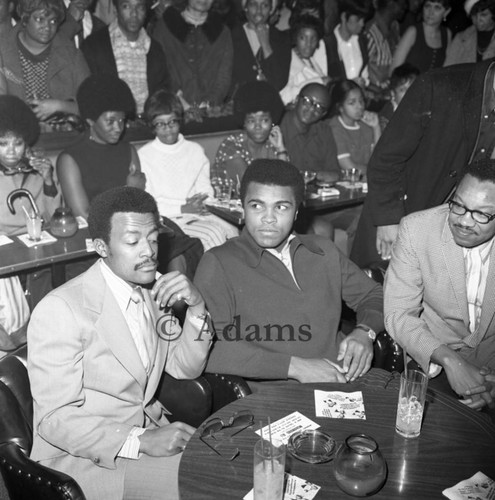 Muhammad Ali, Johnny Cochran, and Brad Pye, Jr. sitting together at the Pied Piper club, Los Angeles, 1970